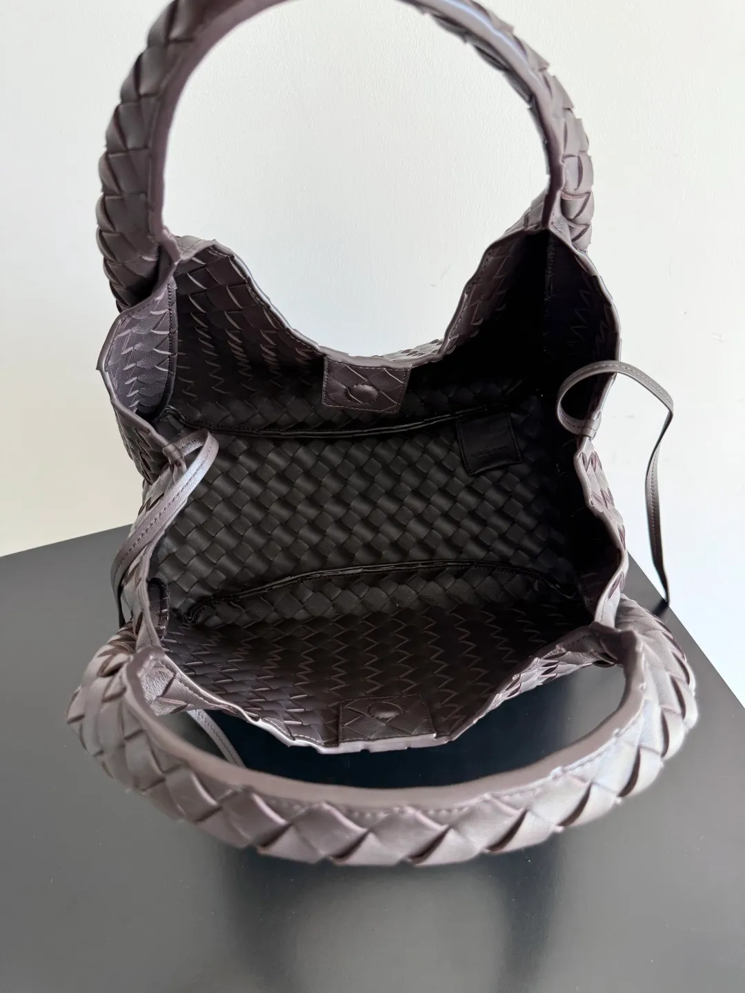 Batch 2160 new products are coming! BOTTEGA VENETA Bottega Veneta's 2025 new Campana shoulder bag is on the market~ First of all, I would like to praise the weight of this bag. As a not too small bag, it is very light for daily use. For people like me who need to carry a lot of belongings when going out, this advantage is great, and it greatly reduces the burden of traveling. 🛍️The shape is a bit like a combination of parachute and jodie. The blunt triangle shape is cute and honest. Carrying it on your back when going shopping is a good mood accelerator. The handles and body of the bag are both classic weaves. A tie is added to the original open design. If it is not tied up, the bag will look like a small vegetable basket when carried. Style number: 844249 Size: 33*20*16.5cm